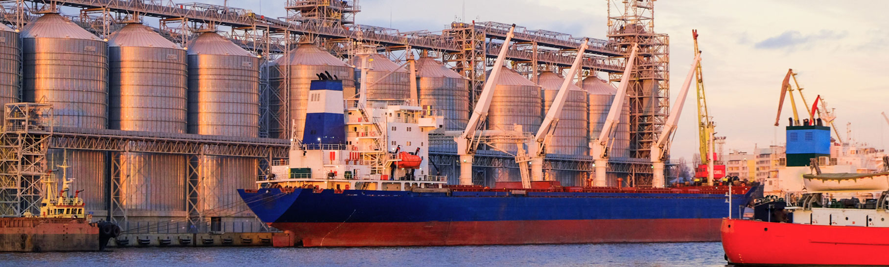 Bulk carrier ship in river port. Dry cargo grain elevator trade. 