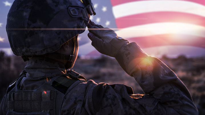 American soldier salutes the American flag.