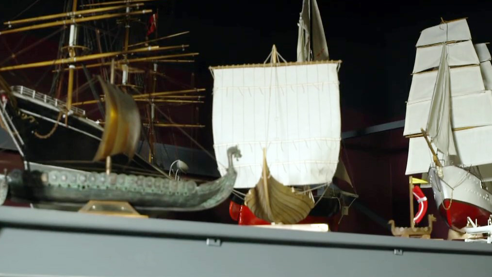 Small, Danish-style model ships on a storage shelf.