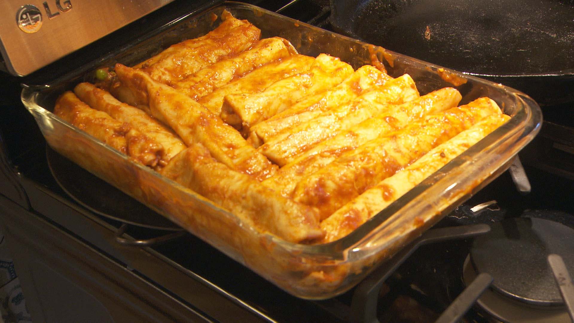 A pan of enchiladas on a stove. 