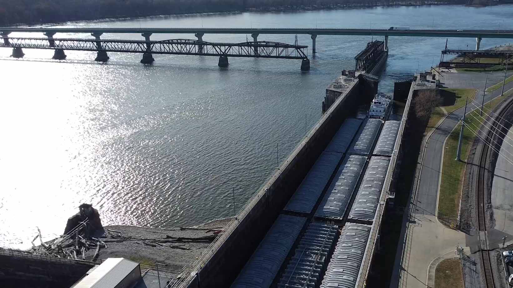 A flat-bottomed boat carrying freight passes through the lock number 19 at Keokuk.