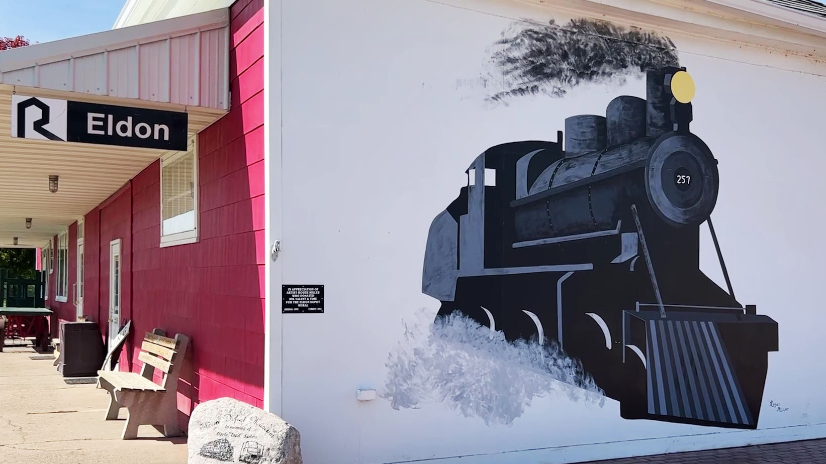 The outside view of the Rock Island Train Depot in Eldon, Iowa showing a mural of a train.