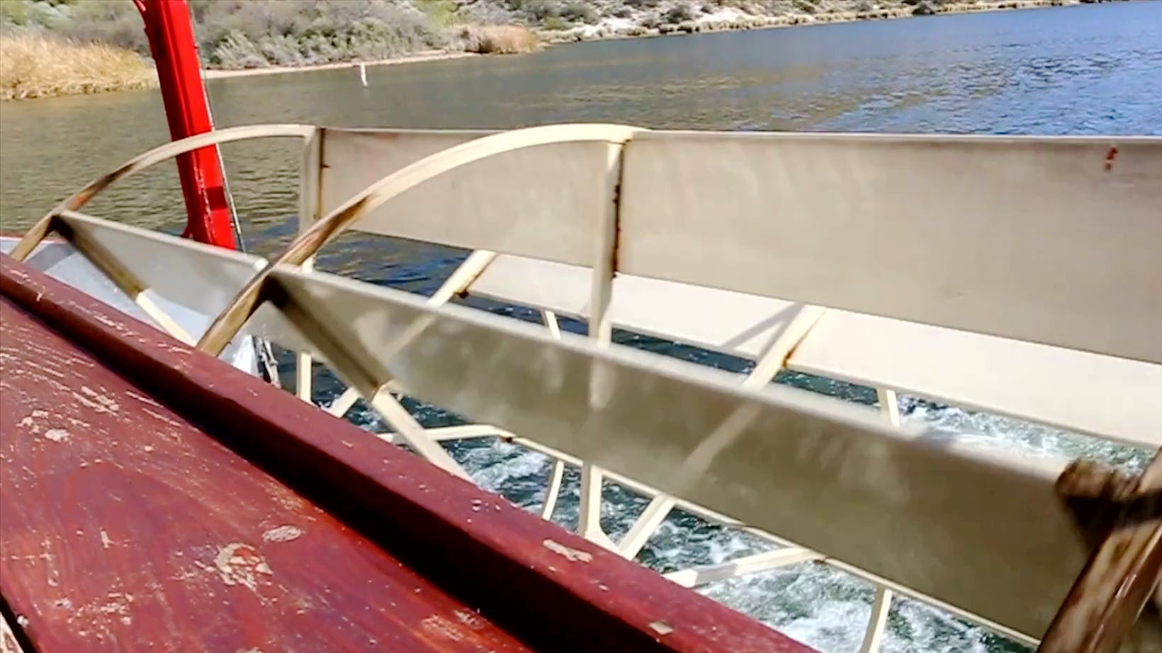 The paddle wheel of a steamboat turning to propel a steamboat on the river.