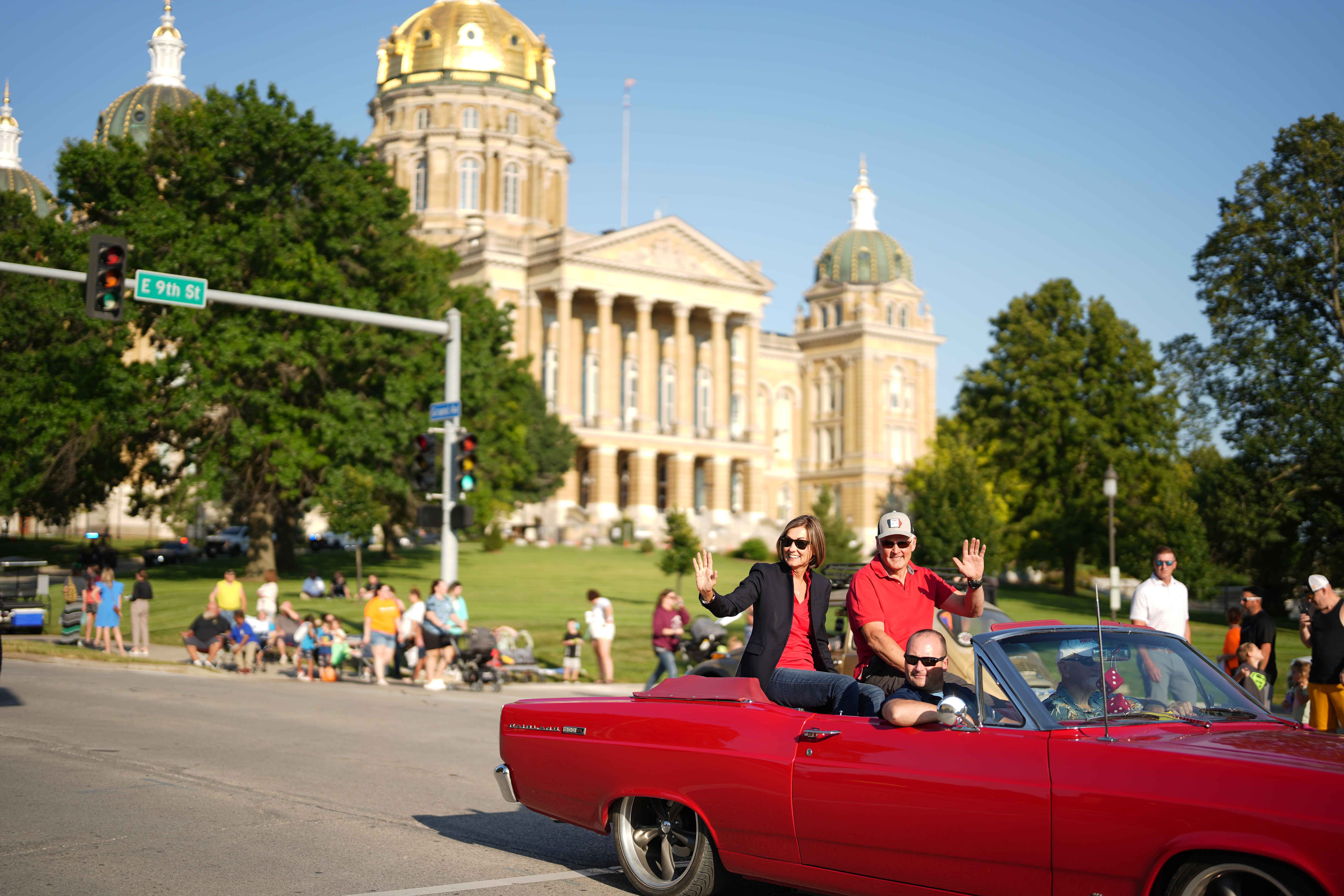 Governor Reynolds waves to the crowd from a convertible.