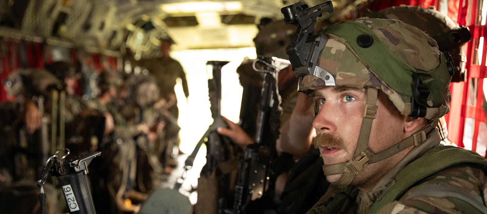 Soldiers of the Iowa National Guard site facing each other in a military aircraft