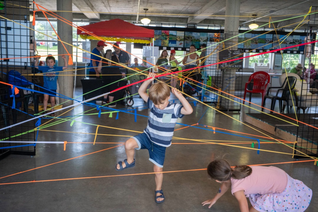 little boy crawling through string in the Cultural Building at the Iowa State Fair