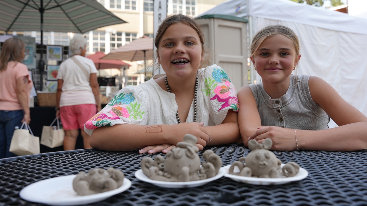 Two girls posing with their clay octopuses 