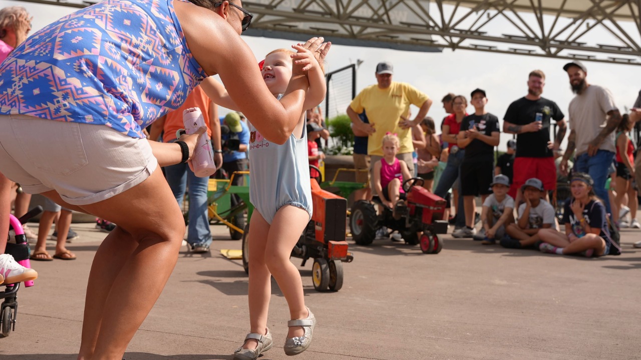 little girl jumping into her mom's arms
