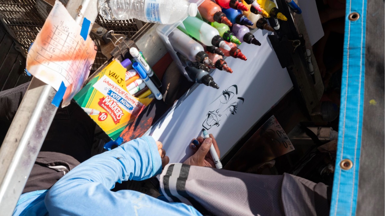 A caricature artist drawing a face on their canvas