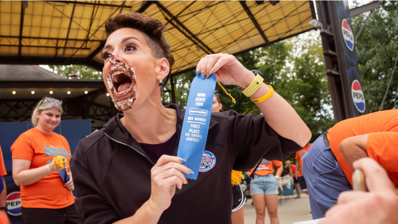 Jackie Schmillen celebrating a blue ribbon in the pie eating contest