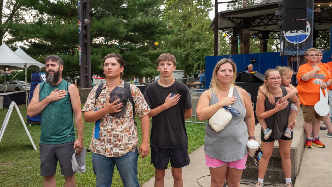 Fairgoers standing for the National Anthem