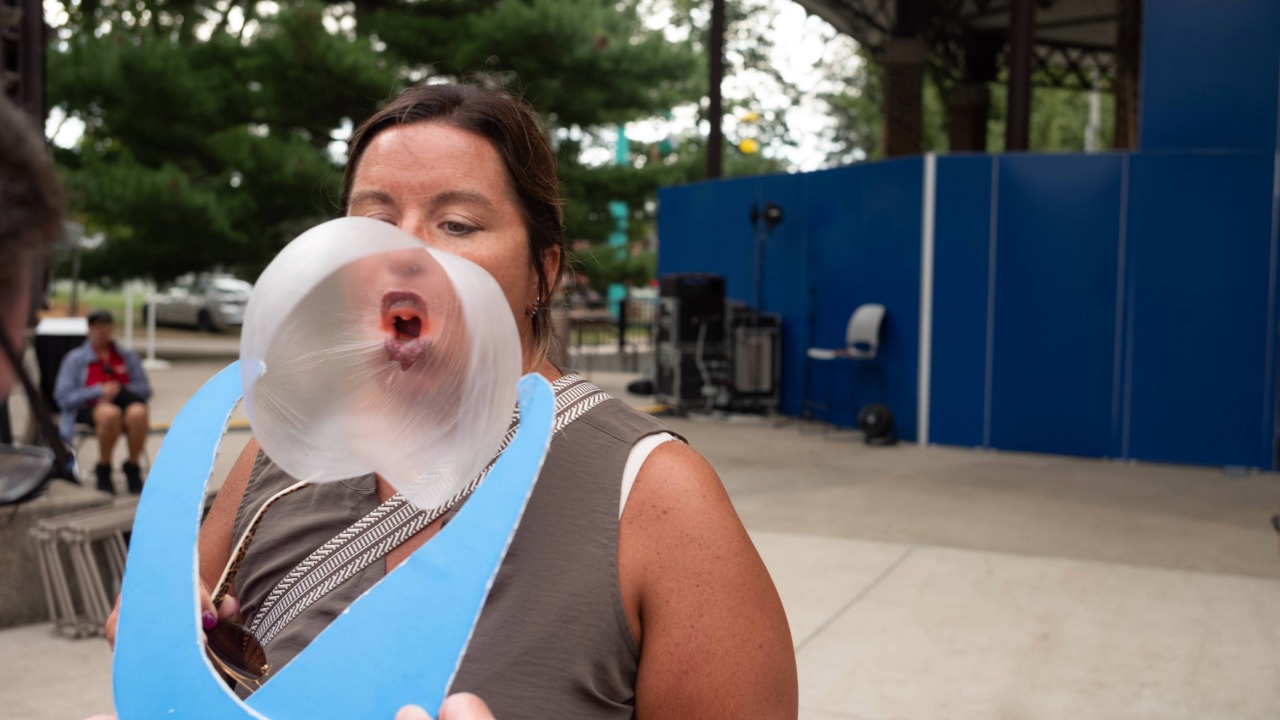 Lady blowing bubble that's bursting