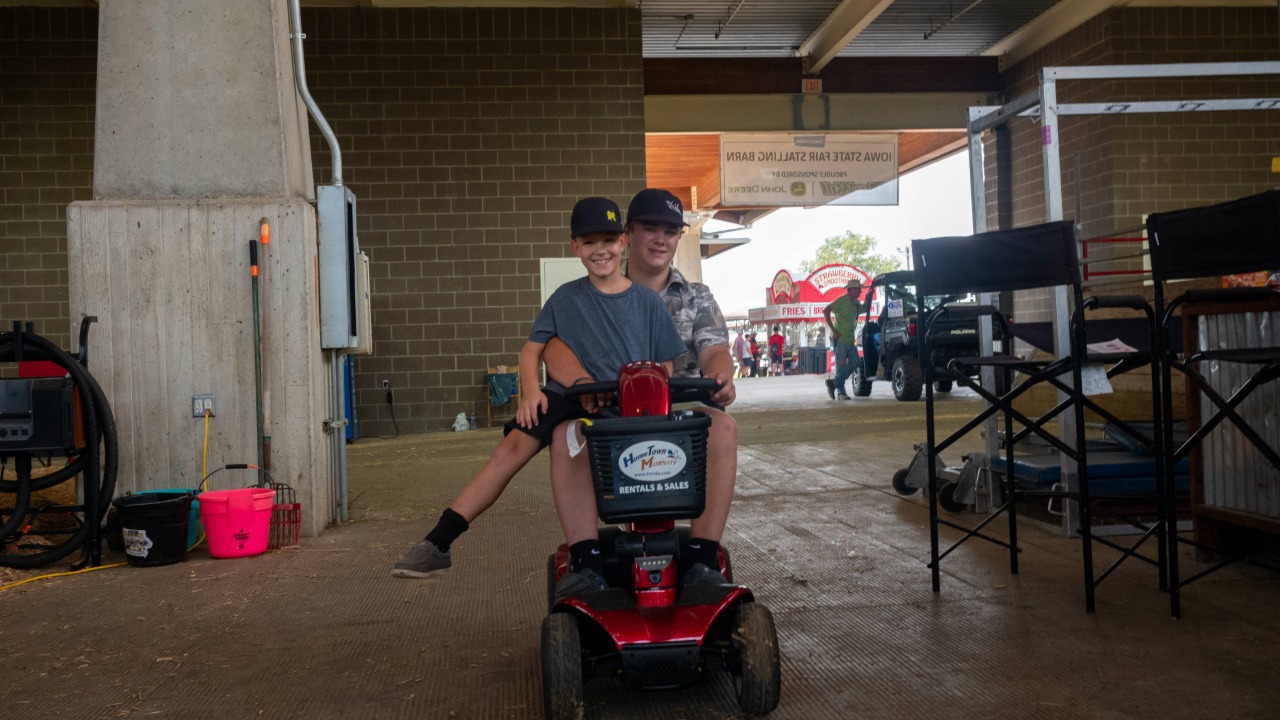 Duo taking a ride on a scooter at the fairgrounds