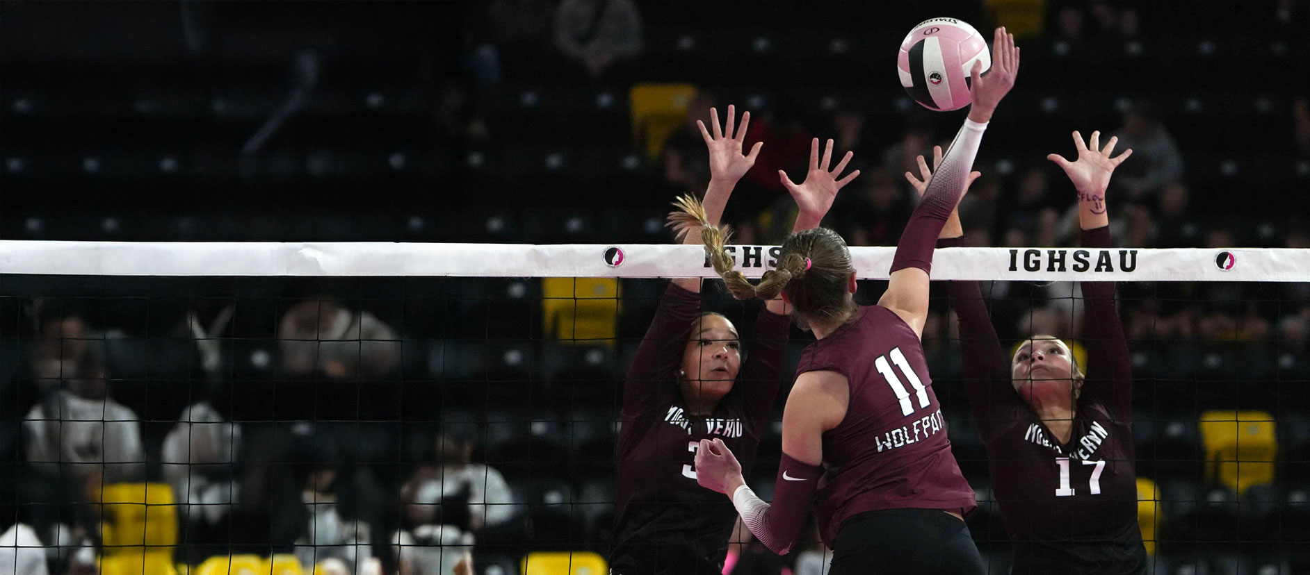 Three high school girls playing volleyball