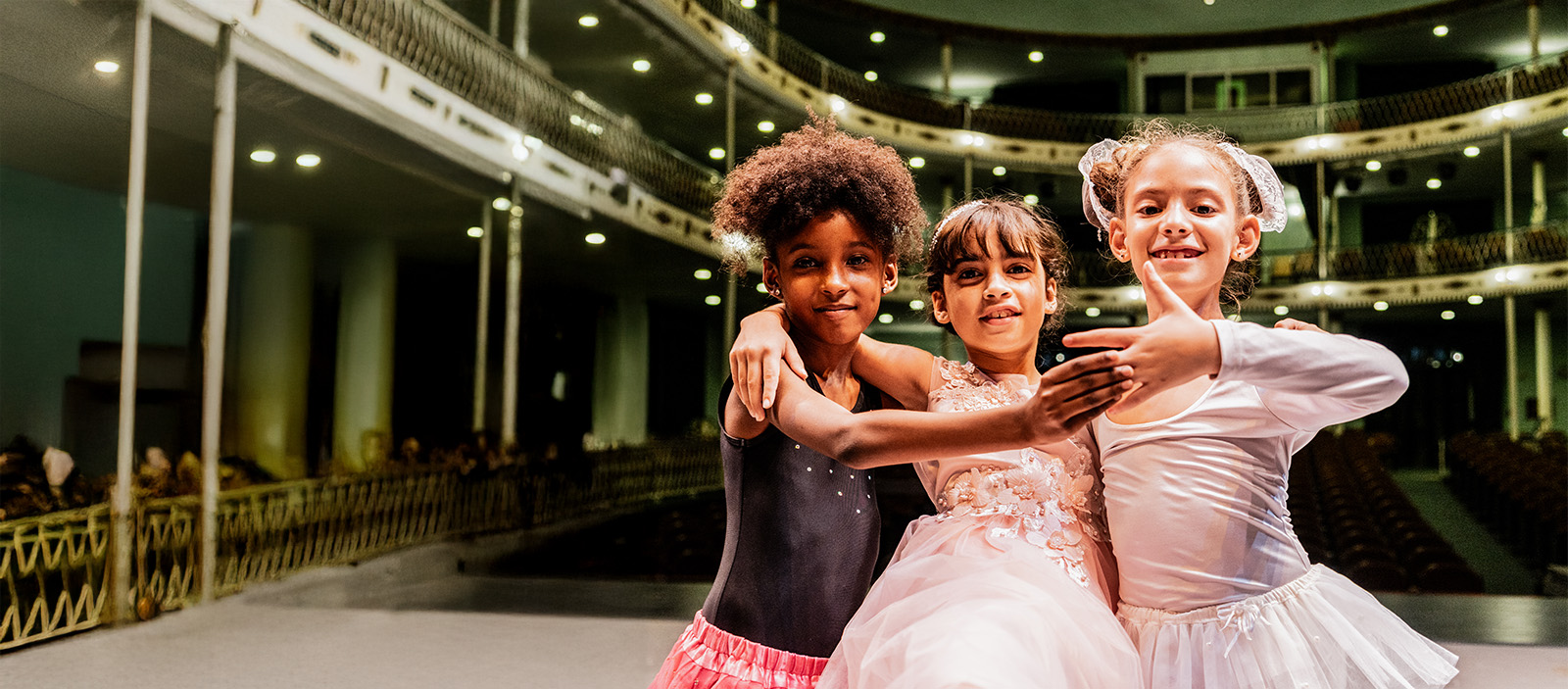 Three young girls dancing together on stage.