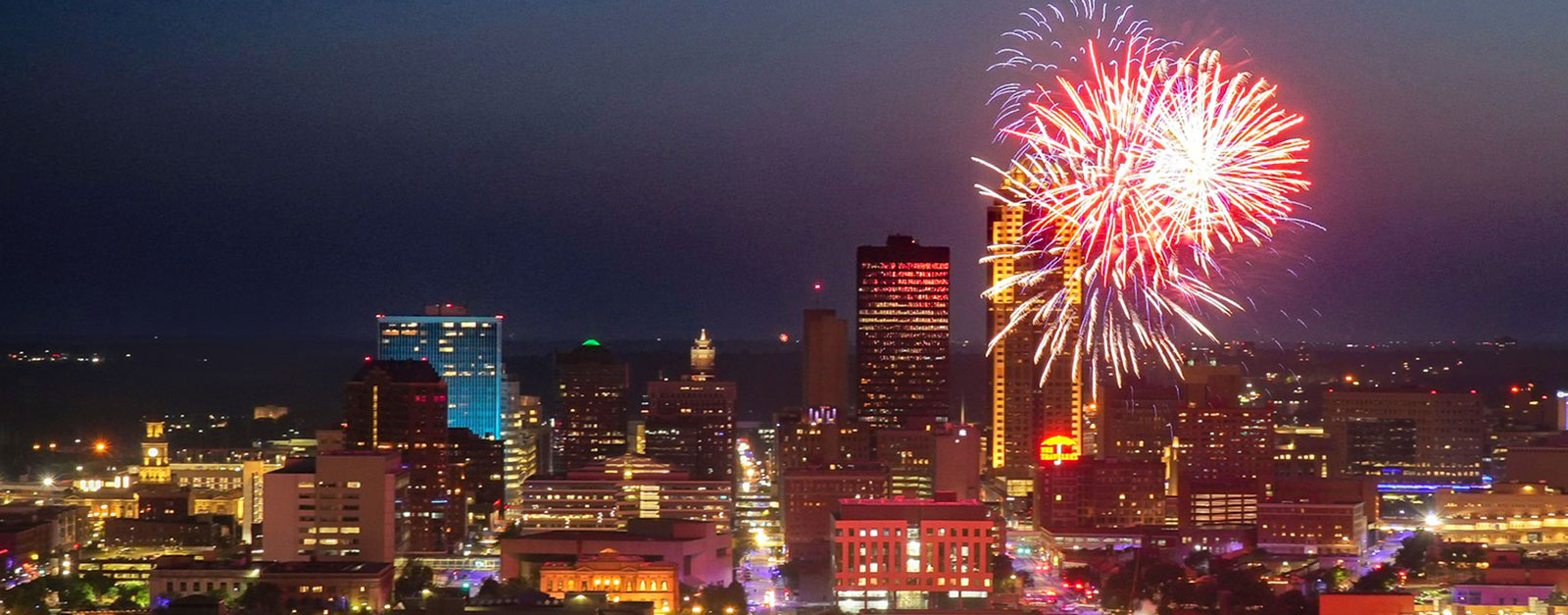 Red and purple fireworks fill the sky over downtown Des Moines.
