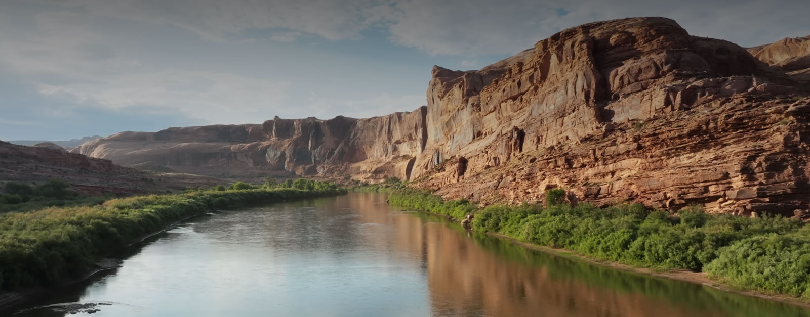 Bluffs and vegetation line a curve in the Colorado River.