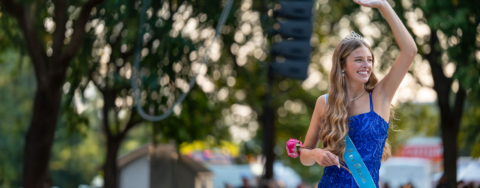 2025 Iowa State Fair Queen Riah Schrage waves to a crowd.