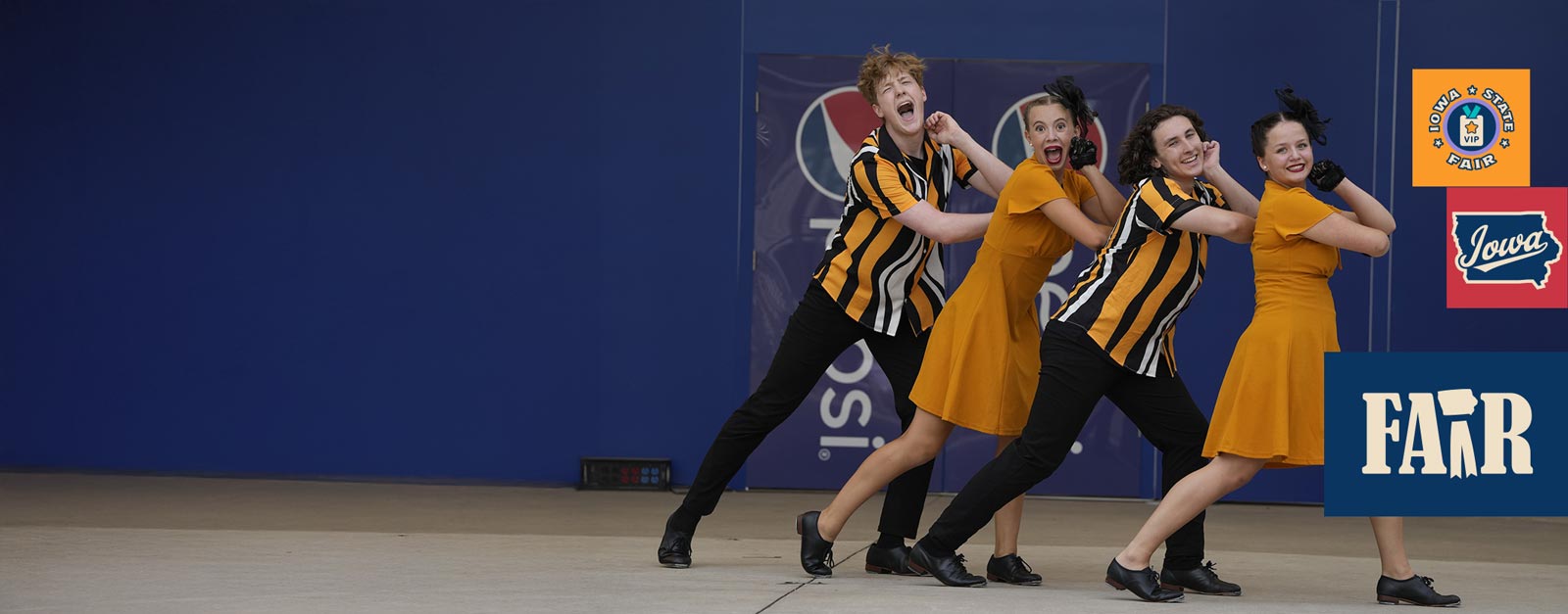 Two male and two female dancers in black and yellow costumes.