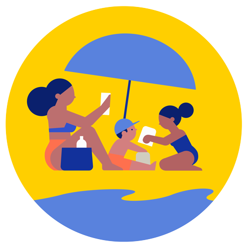 An adult woman and two children sit beneath a large beach umbrella.
