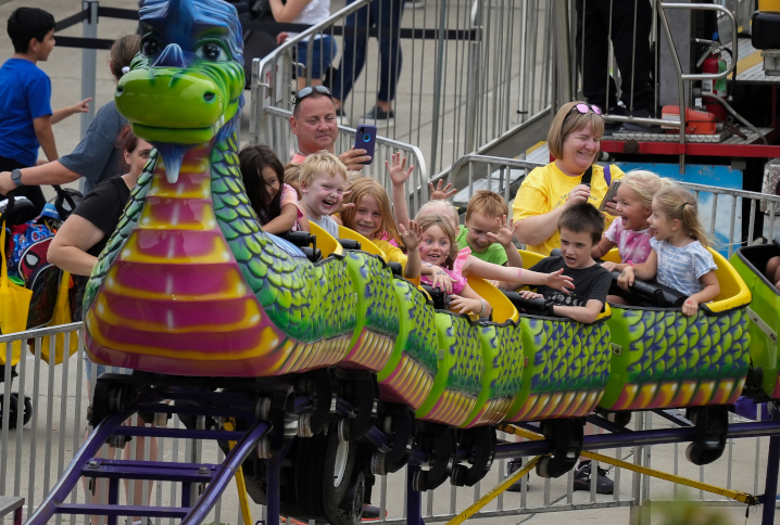 Young fairgoers ride on a dragon roller coaster in Thrilltown 