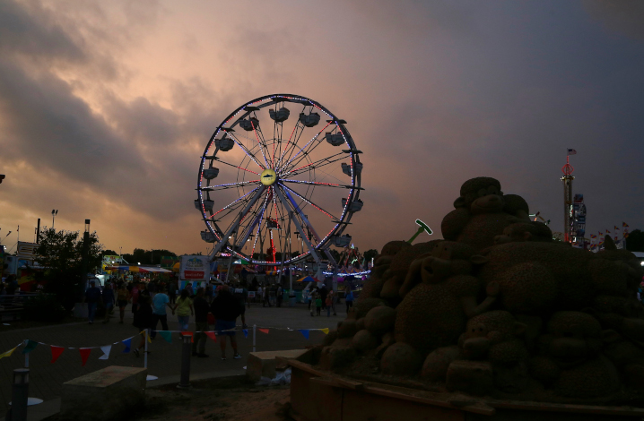 Dark clouds build over the midway during the Iowa State Fair on Monday, Aug. 14, 2023