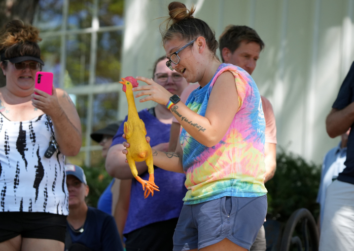 rubber chicken throwing participant investigating their chicken