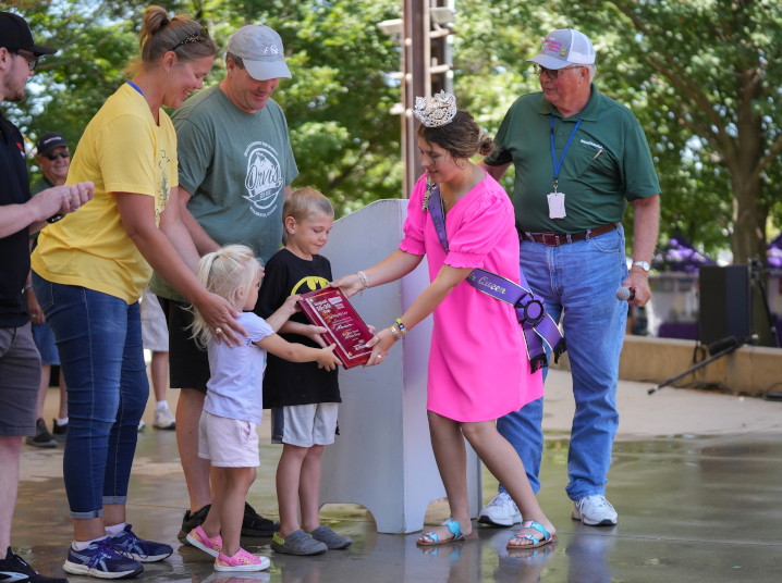 Iowa State Fair queen handing out an award to two kids