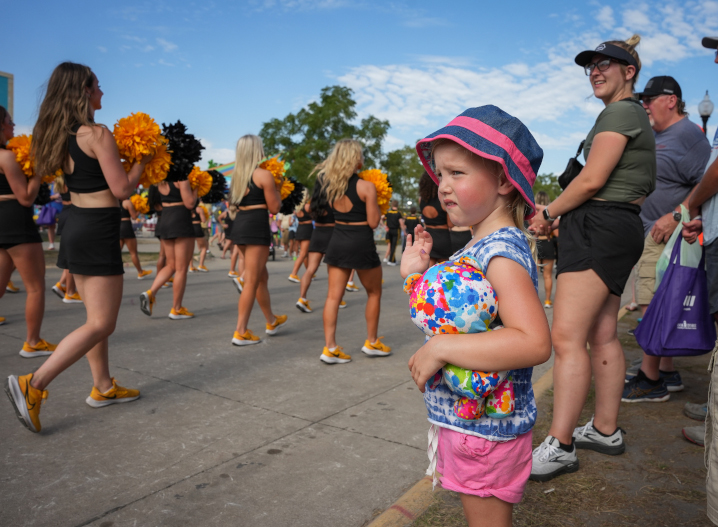 little girl waving to the Hawkeye Marching Band 