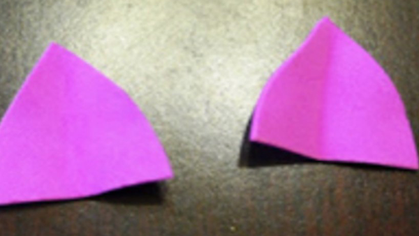 two pink paper triangles cut out to look like pig’s ears