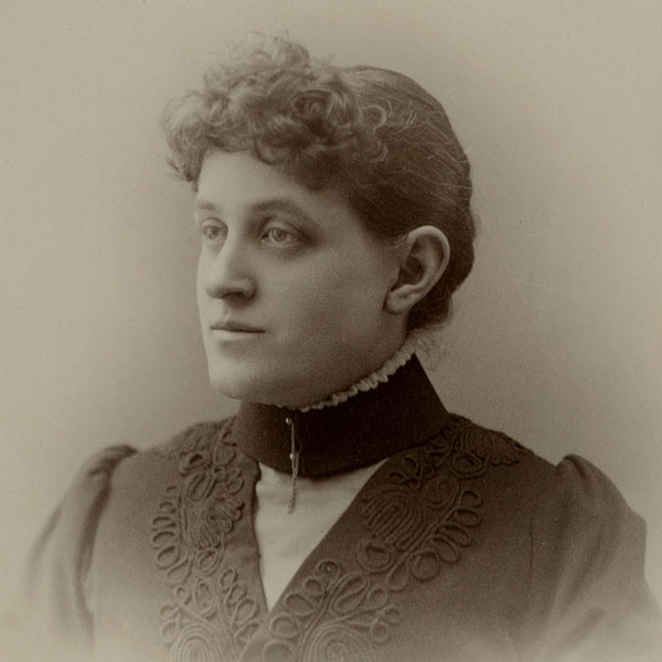 A young woman wearing a high-collared dress