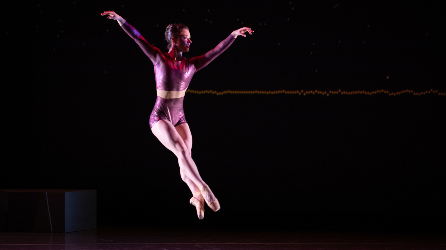 A ballet dancer in the air mid-jump