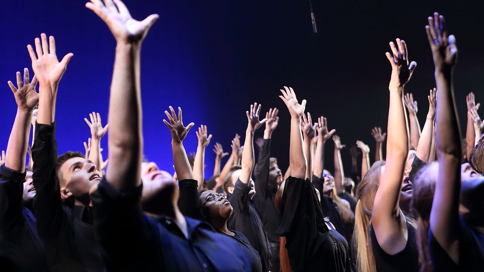 Iowa students singing with arms in the air