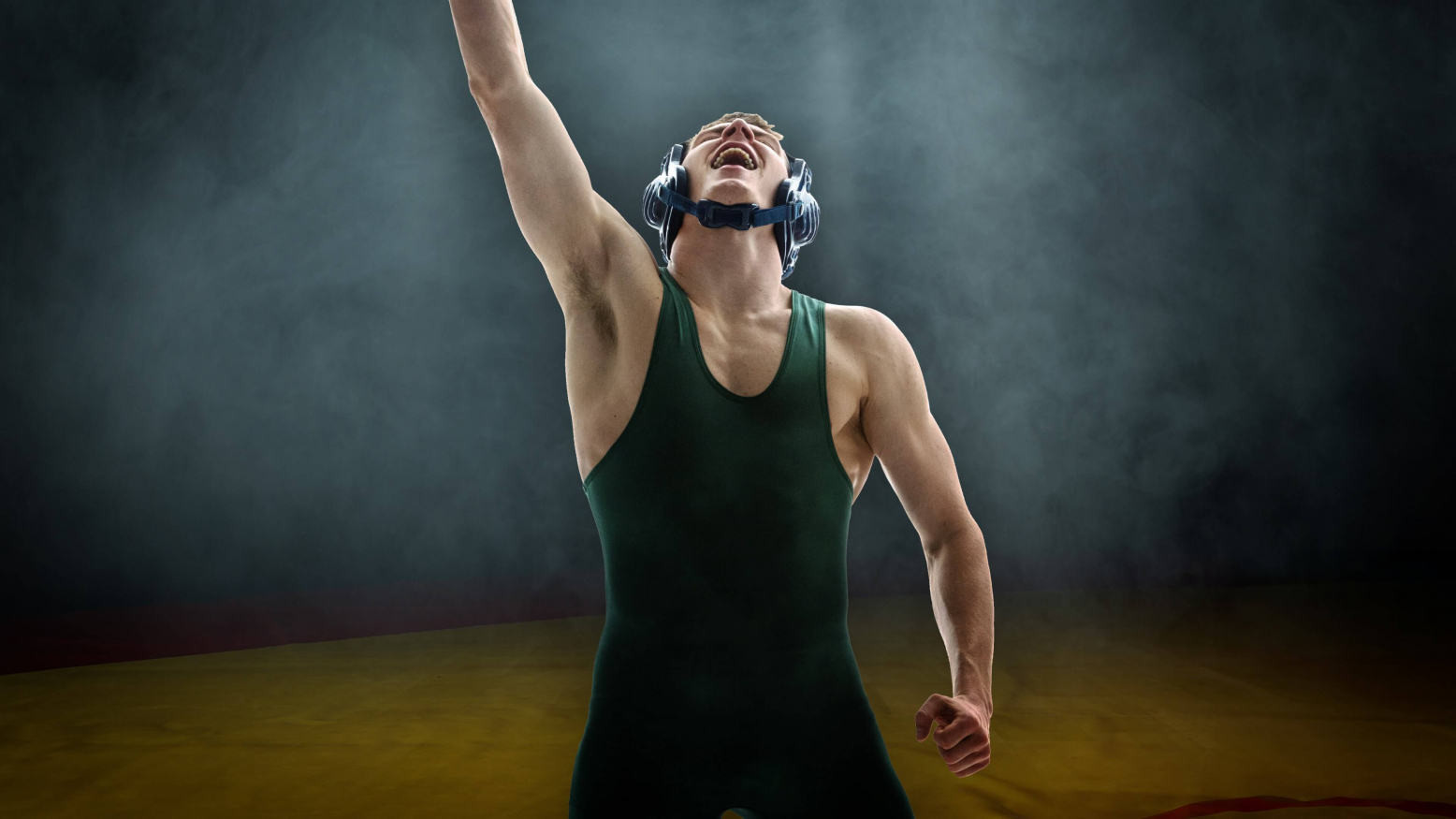 college wrestler holding up his arm in the air