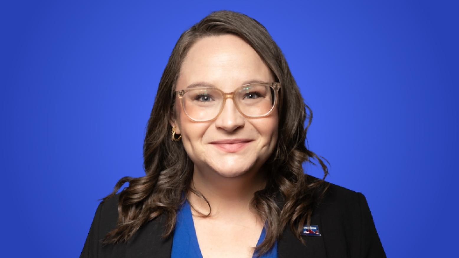 Caryline Clark, a woman with brown hair and glasses smiing at the camera. 