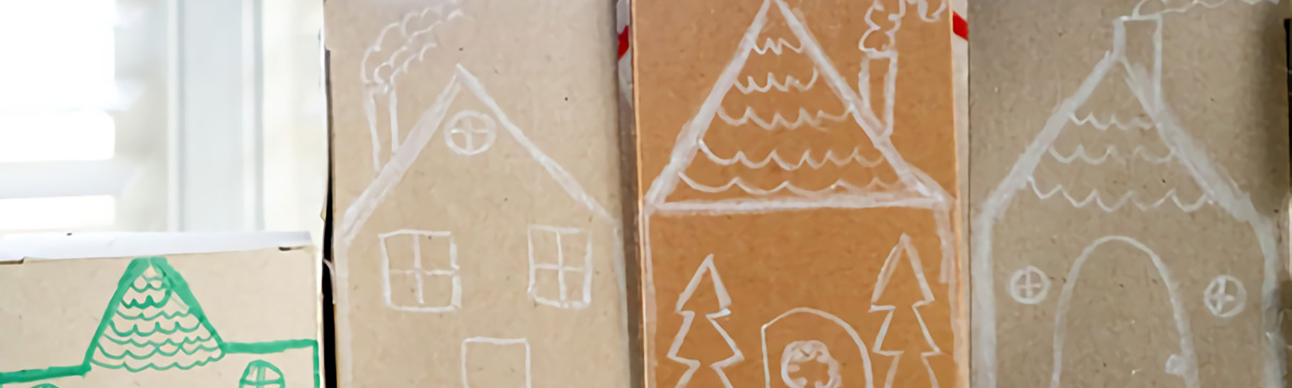 Brown boxes turned upside down and drawn on to resemble a gingerbread village.