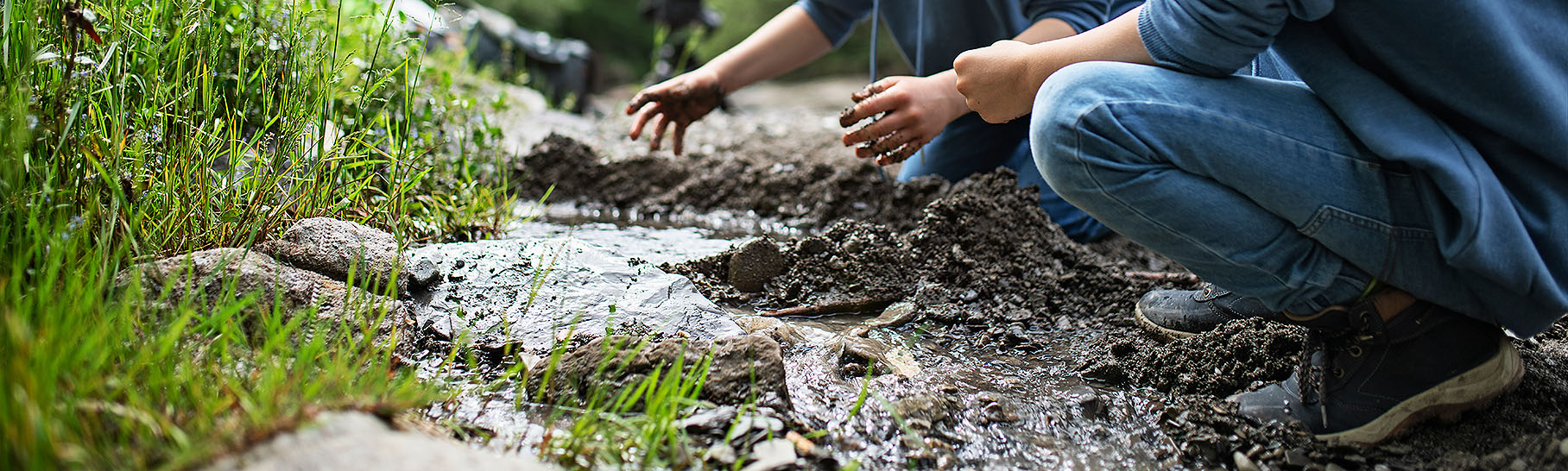 Two boys making a dam in nature.