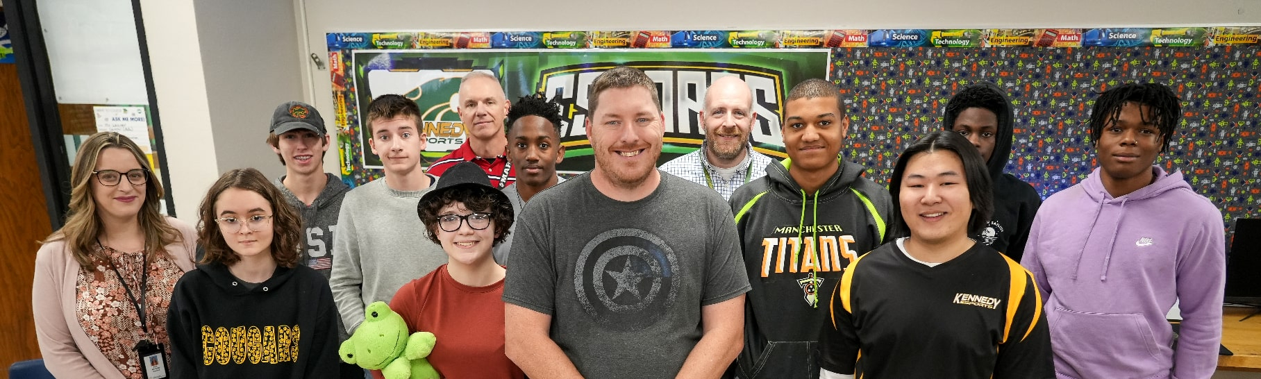 Cedar Rapids Kennedy teacher Jason Lester and several of his current and former students standing in a classroom