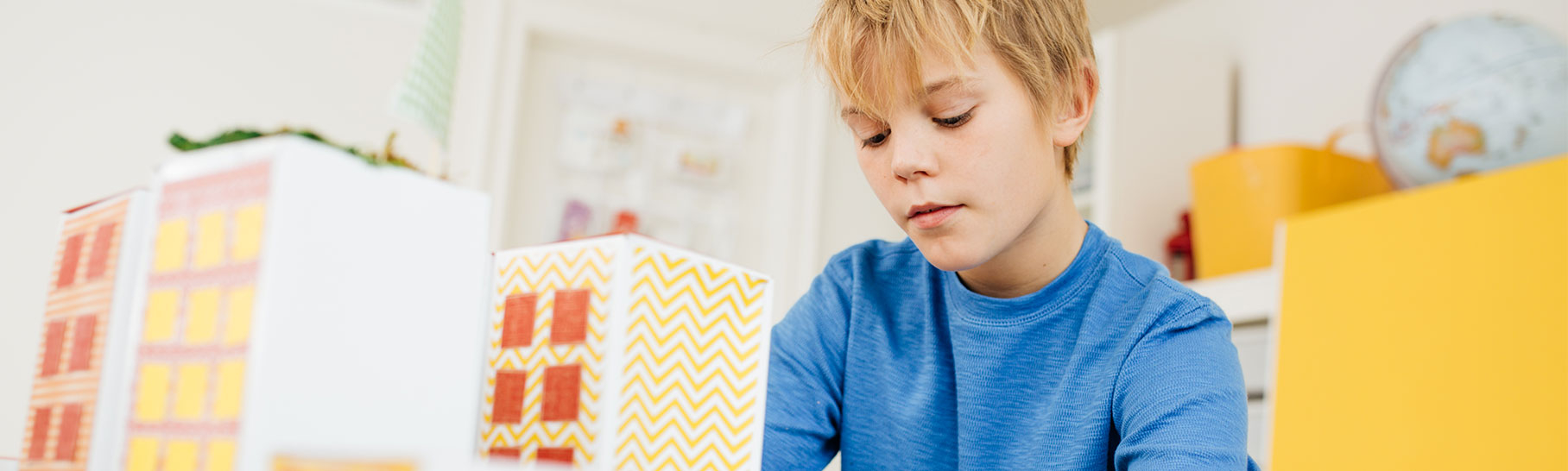 A 7-year-old boy builds skyscrapers out of paper.