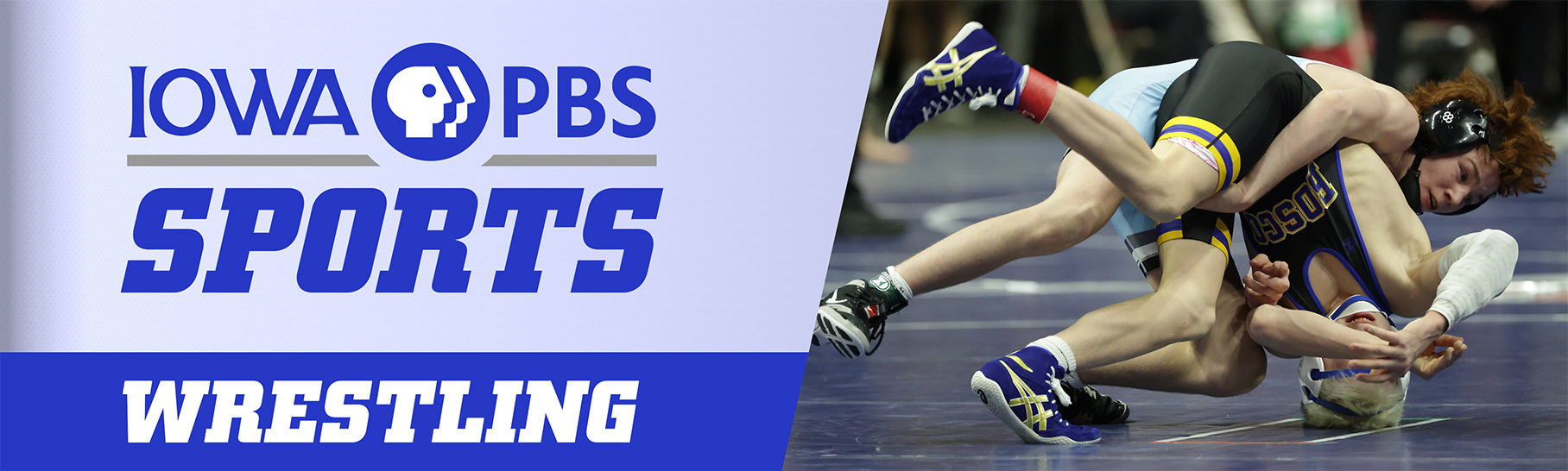 Two wrestlers competing on a blue mat, with one pinning the other.