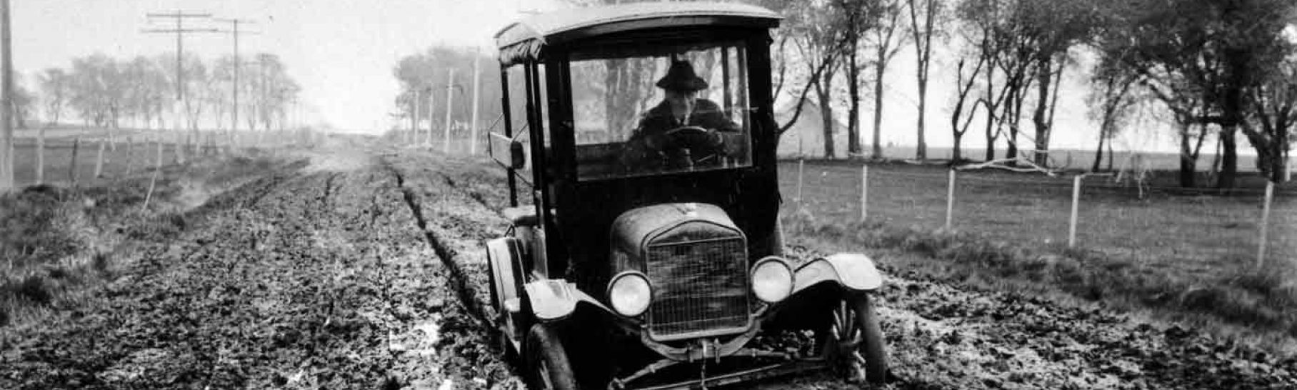 Car stuck in muddy road. ca. 1920.