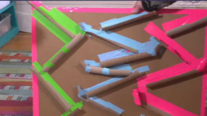 A completed marble run using pink, green, and blue masking tape to designate each run.
