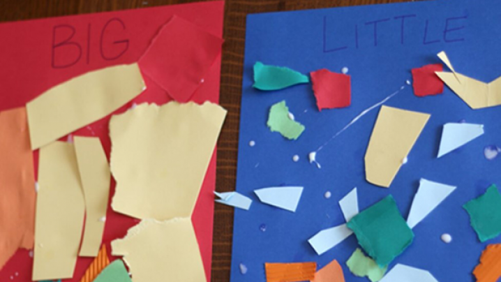 Two pieces of construction paper. One is red and one is blue. At the top of the red paper it says “big.” At the top of the blue paper it says “little.” There are pieces of paper of various sizes on the red and blue paper.