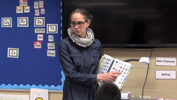 teacher using an assistive tool to show students how to find key ideas in a fictional story.