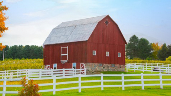 A red barn surrounded by farm fields