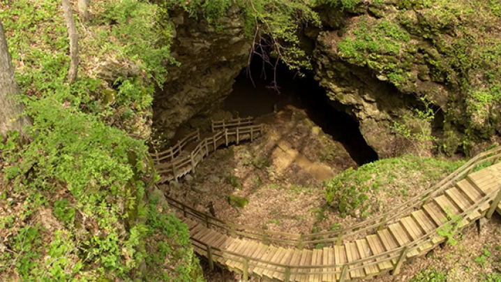 Overhead view of the opening of the Maquoketa Caves and the wooden steps leading down to the opening.