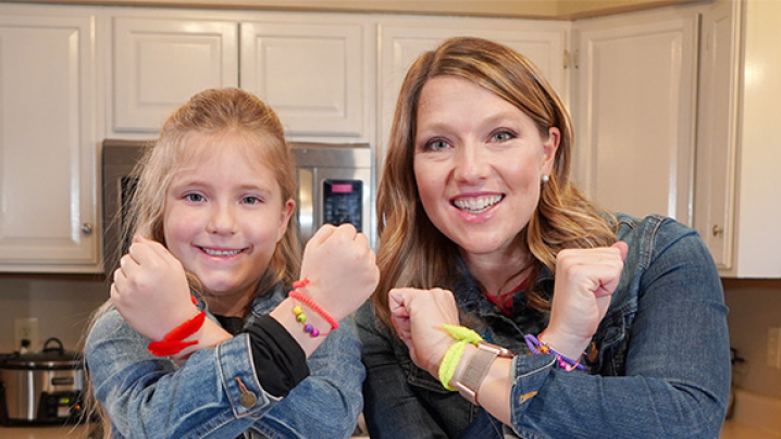Abby and her friend showing off their homemade bracelets