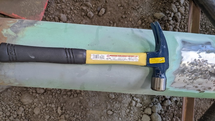 Steel hammer on a metal pipe