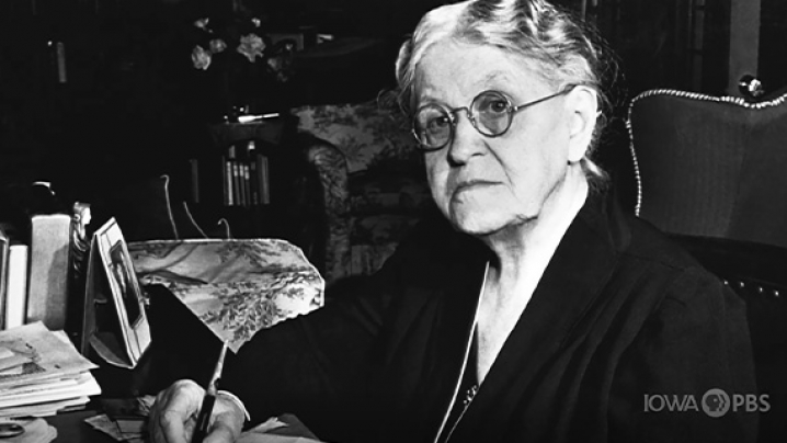 Carrie Chapman Catt sitting at a writing desk.
