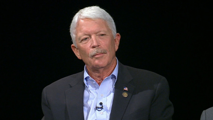 Dan Gannon. A man with short white hair that parts to the side. He is wearing a dark suit jacket and a light blue dress shirt.